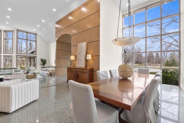 dining room with a wealth of natural light, floor to ceiling windows, and a high ceiling