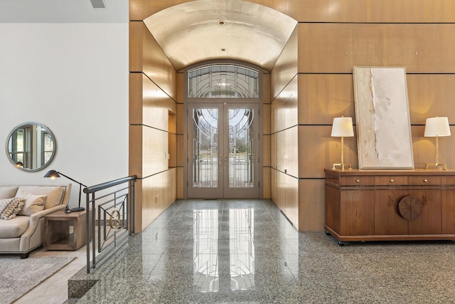 entryway with vaulted ceiling, granite finish floor, and french doors