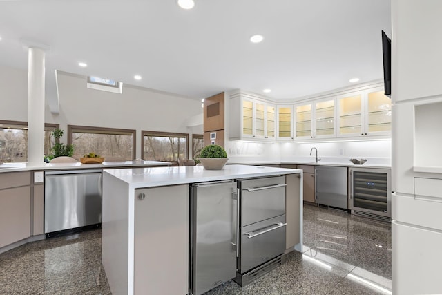 kitchen featuring granite finish floor, recessed lighting, wine cooler, and stainless steel dishwasher