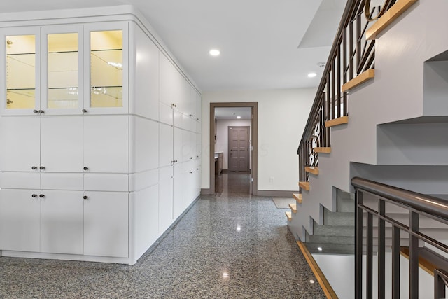 hallway with stairway, granite finish floor, recessed lighting, and baseboards