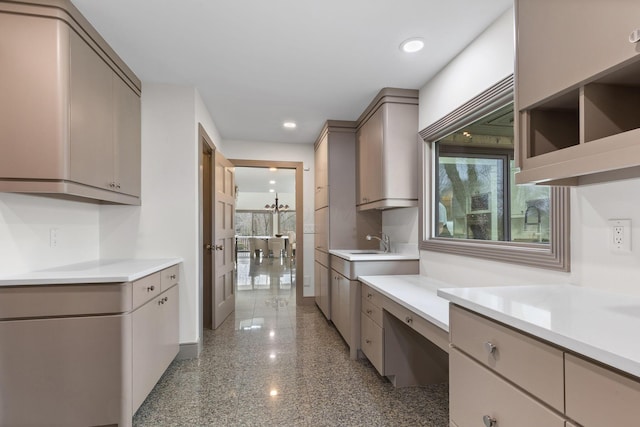 kitchen featuring granite finish floor, recessed lighting, gray cabinets, a sink, and light countertops