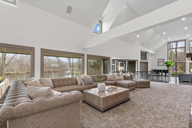 living room featuring recessed lighting, high vaulted ceiling, and a water view