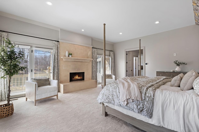 carpeted bedroom featuring recessed lighting, a tile fireplace, and access to outside