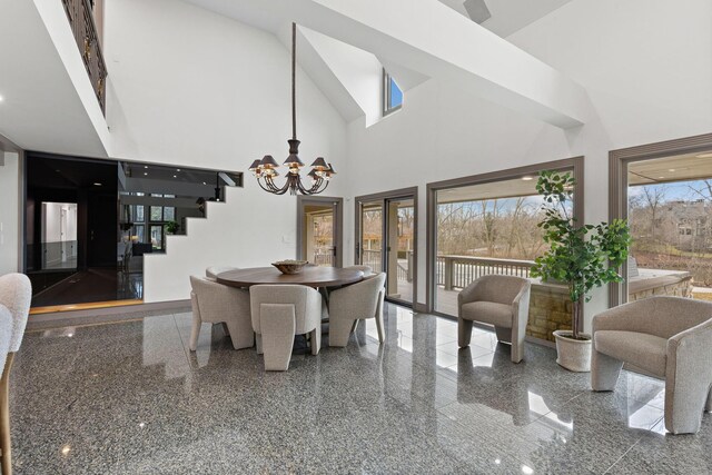 dining space featuring a notable chandelier, high vaulted ceiling, and granite finish floor