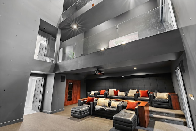 carpeted home theater room featuring a towering ceiling