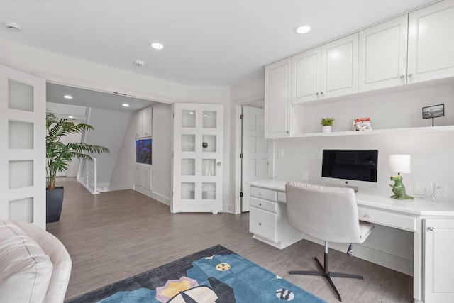 office with recessed lighting, dark wood-type flooring, and built in desk