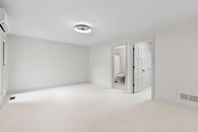 unfurnished bedroom with baseboards, visible vents, an AC wall unit, and carpet