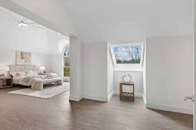 bedroom with wood finished floors, baseboards, and high vaulted ceiling