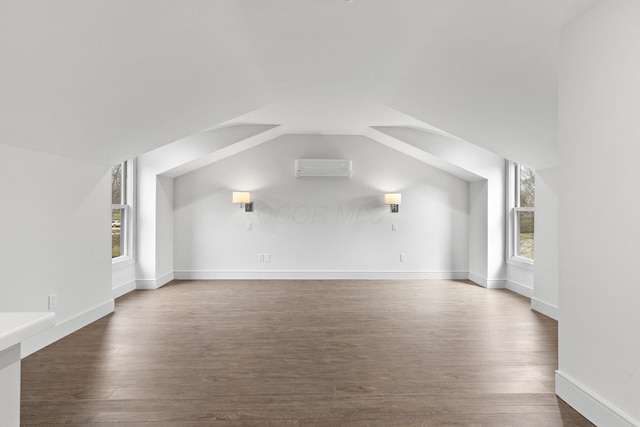 bonus room featuring vaulted ceiling, dark wood-style floors, baseboards, and a wall mounted AC