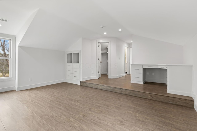 bonus room featuring vaulted ceiling, wood finished floors, and baseboards