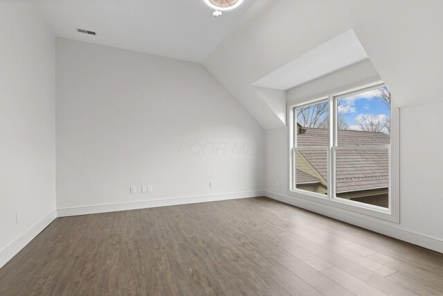 additional living space featuring lofted ceiling, wood finished floors, and baseboards