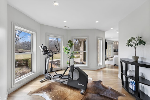 workout room featuring a wealth of natural light, light wood-style floors, and recessed lighting