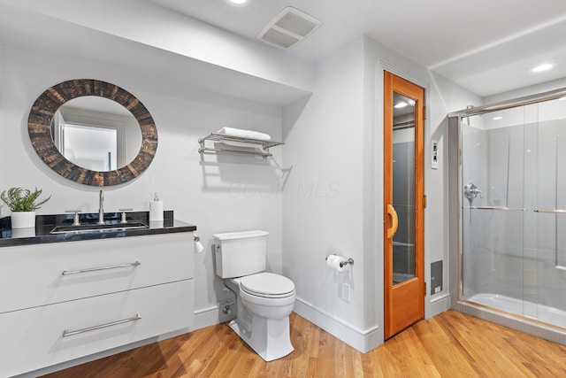 bathroom with visible vents, a shower stall, toilet, and wood finished floors