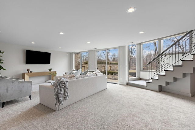 living area with floor to ceiling windows, recessed lighting, stairway, carpet flooring, and baseboards