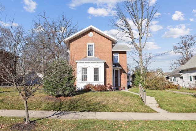 view of front facade with a front yard and brick siding