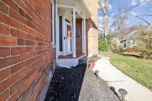 view of exterior entry featuring brick siding