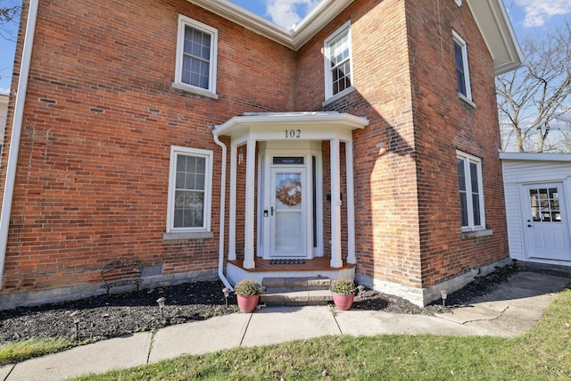 doorway to property featuring brick siding