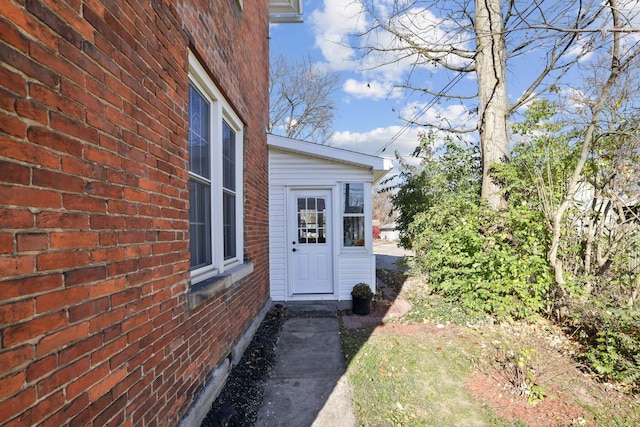 view of exterior entry featuring brick siding