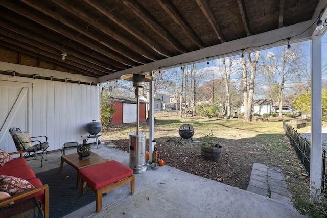 view of patio with an outbuilding, area for grilling, a storage unit, and fence