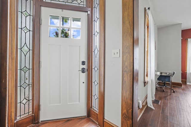 foyer entrance featuring baseboards and hardwood / wood-style flooring