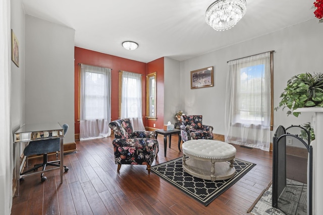 sitting room featuring a chandelier, baseboards, and hardwood / wood-style floors