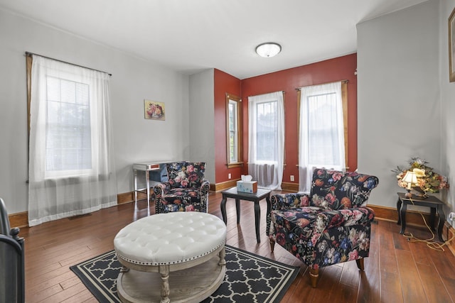 living area featuring baseboards and wood-type flooring