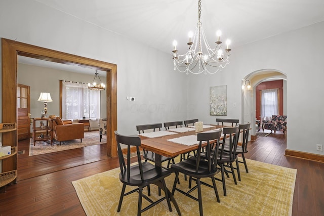 dining space with a wealth of natural light, baseboards, arched walkways, and hardwood / wood-style floors