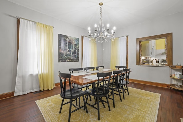 dining room with visible vents, baseboards, a notable chandelier, and hardwood / wood-style flooring