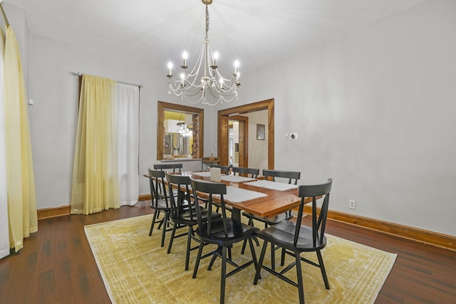 dining space featuring an inviting chandelier, baseboards, and wood finished floors