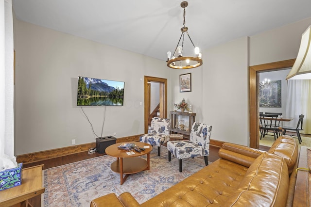 living room with baseboards, wood finished floors, and a chandelier