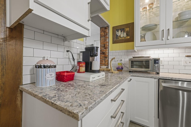 kitchen featuring tasteful backsplash, a toaster, and dishwasher