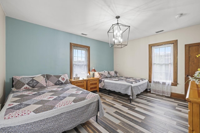 bedroom featuring visible vents, baseboards, and wood finished floors