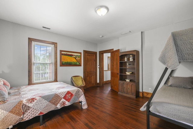 bedroom featuring visible vents, dark wood-type flooring, and baseboards