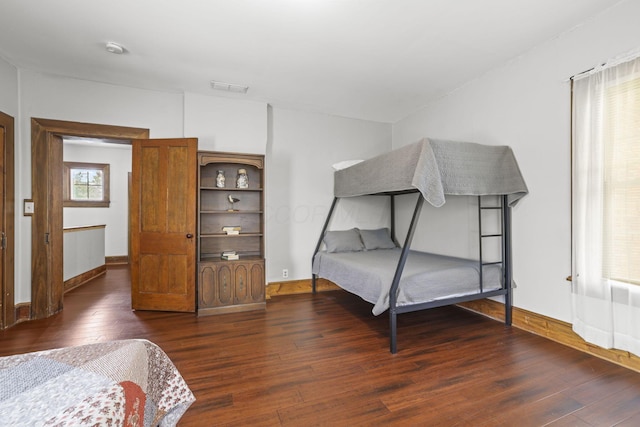 bedroom with visible vents, baseboards, and wood-type flooring