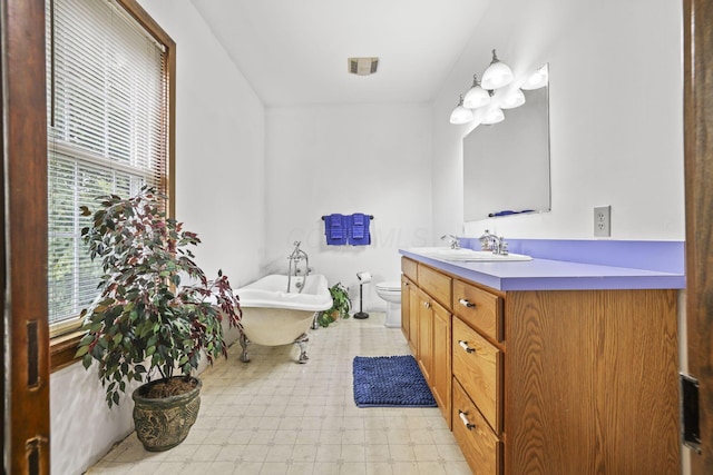 bathroom with tile patterned floors, visible vents, toilet, a soaking tub, and vanity