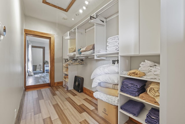 spacious closet featuring attic access and light wood-style floors