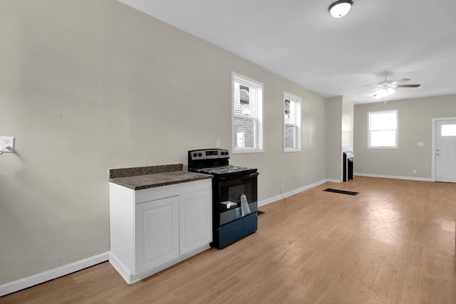 kitchen featuring light wood-type flooring, electric range, baseboards, and a ceiling fan