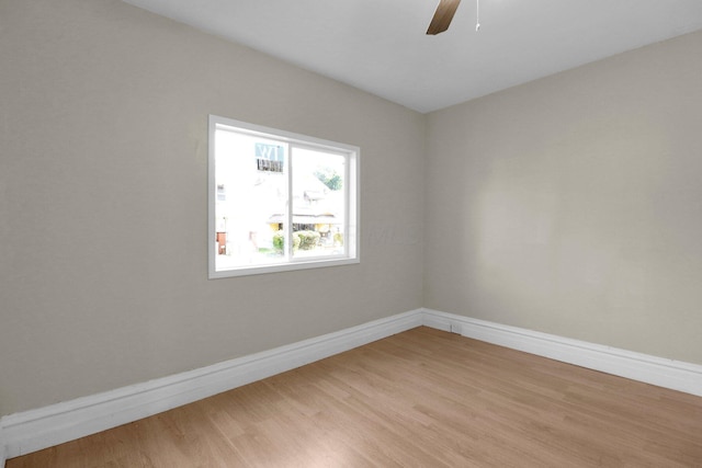 unfurnished room featuring a ceiling fan, baseboards, and light wood finished floors