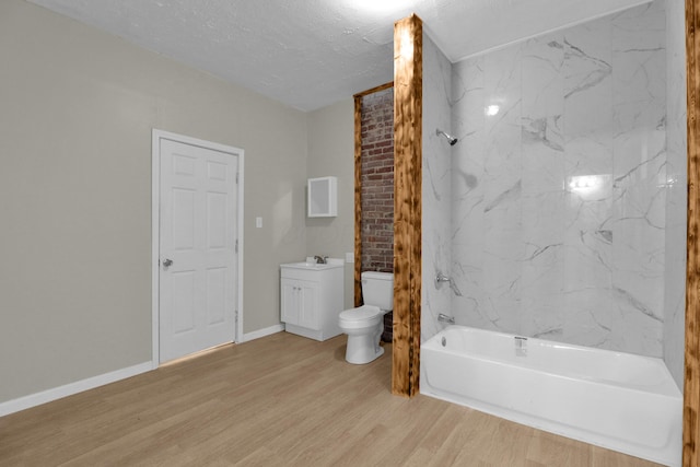 bathroom with bathtub / shower combination, toilet, a textured ceiling, vanity, and wood finished floors