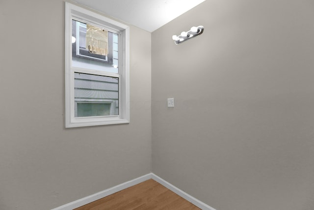 unfurnished room featuring baseboards and wood finished floors