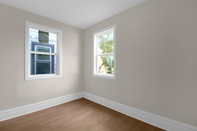 spare room featuring baseboards and wood finished floors