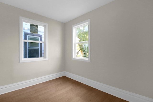 spare room with wood finished floors and baseboards