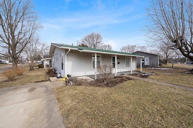 view of front of house with a porch, a front yard, and metal roof