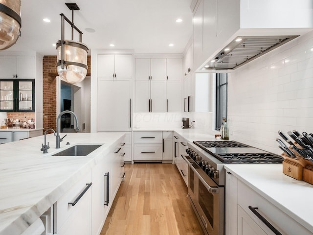 597 S 9th St, Columbus, OH 43206 - kitchen featuring range with two ovens, a sink, backsplash, light wood-style flooring, and custom exhaust hood