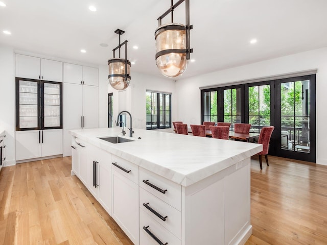 597 S 9th St, Columbus, OH 43206 - kitchen with a sink, recessed lighting, light wood-type flooring, a kitchen island with sink, and white cabinets