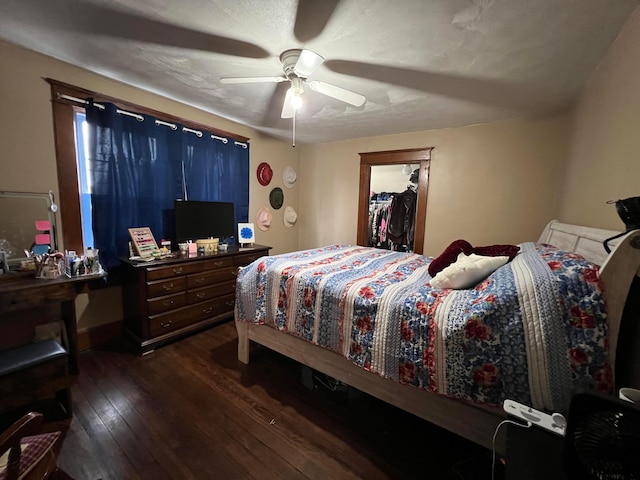 bedroom featuring a ceiling fan, a closet, dark wood finished floors, and a spacious closet