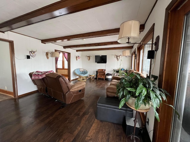 living area featuring baseboards, wood finished floors, and beamed ceiling