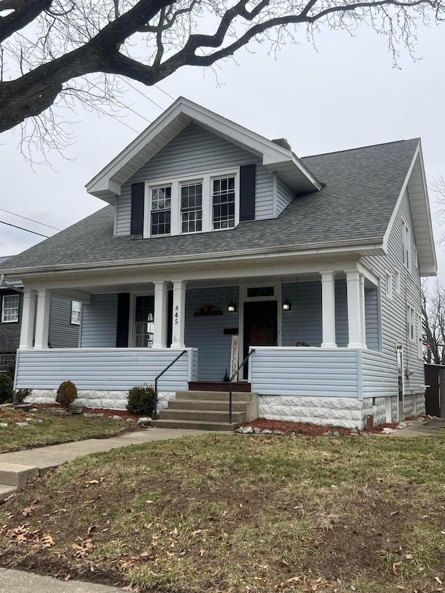 view of front of house featuring a shingled roof and covered porch