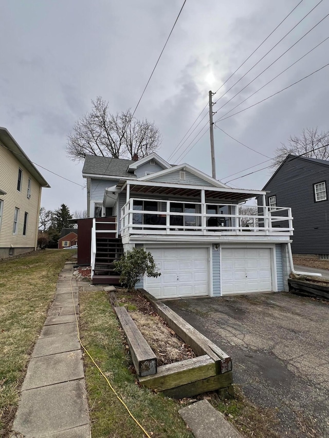 view of front of property featuring a garage, driveway, and stairs