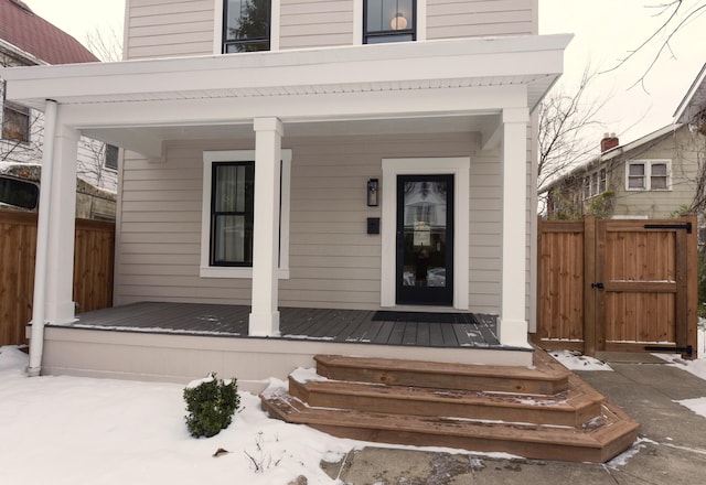 property entrance featuring covered porch, fence, and a gate